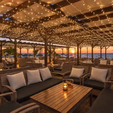 un salon extérieur au coucher du soleil sur la plage 