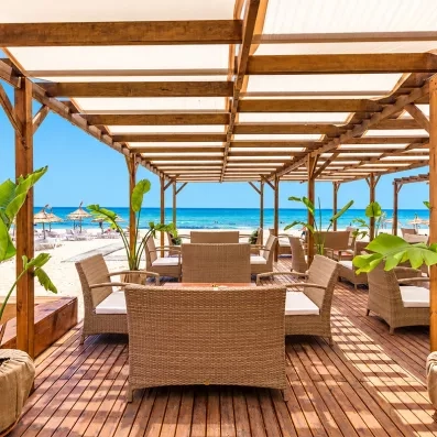 Une terrasse ombragée donnant sur une mer turquoise