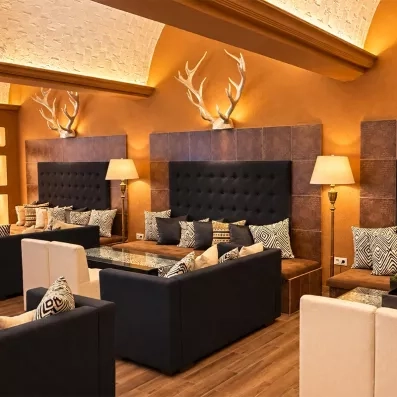 Salon cosy avec banquettes élégantes, panneaux bois et décoration murale raffinée