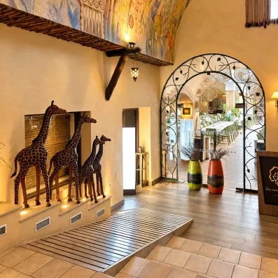 Entrée artistique décorée de fresques colorées, sculptures animales et arche ornée