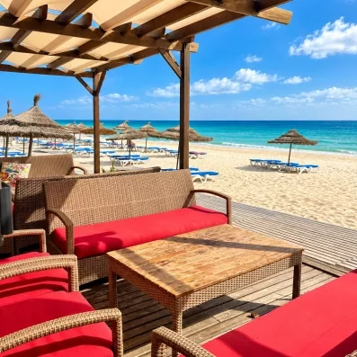 Espace lounge en rotin avec vue directe sur la plage turquoise