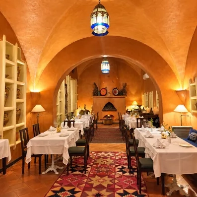 Restaurant intimiste aux tons chauds, éclairé par bougies et lanternes décoratives