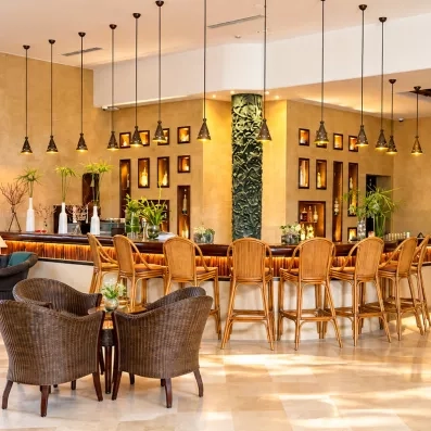 Bar élégant avec comptoir en bois, luminaires suspendus et ambiance chaleureuse