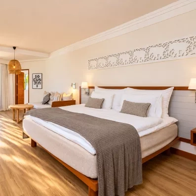 Une chambre spacieuse avec un grand lit double et d'un accès direct à un balcon privé.