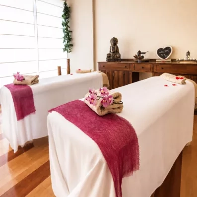 Une cabine de massage apaisante et lumineuse décorée avec des touches de fleurs roses.