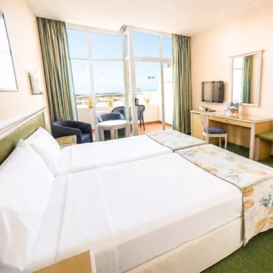 Une chambre confortable offrant une vue dégagée à travers une large baie vitrée.