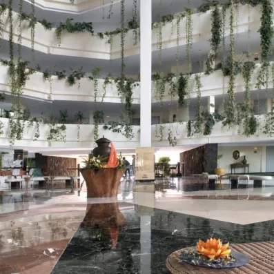 Le hall intérieur de l'hôtel moderne, vaste et lumineux, s'étendant sur plusieurs étages.