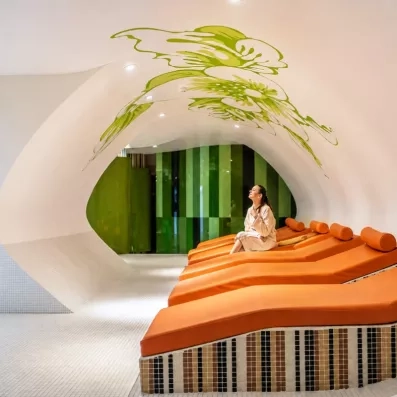 Un espace de relaxation avec des banquettes orange au design organique.