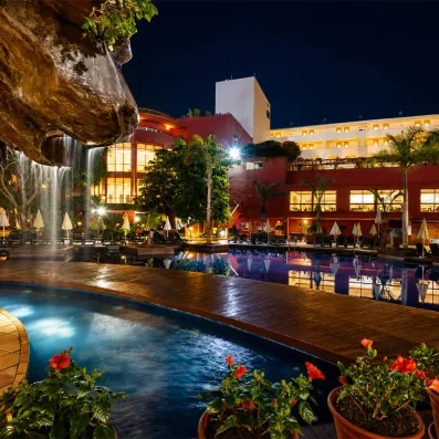 De nuit, on voit les éclairages de l'hôtel et des jardins avec la piscine.
