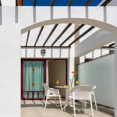Une terrasse privative ombragée par une pergola, idéale pour prendre un verre en extérieur.
