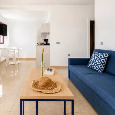 Un gros plan sur la tête de lit bleu marine, avec des coussins et des liseuses modernes de chaque côté.
