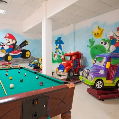 Une salle de divertissement équipée d'une table de billard verte, d'un baby-foot.