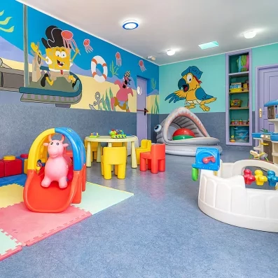 Une aire de jeux intérieure ludique comprenant un petit toboggan, une piscine à balles.