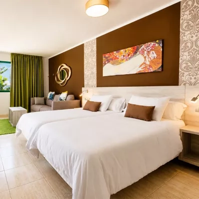 Une chambre spacieuse et lumineuse propose deux lits simples et un petit coin salon.