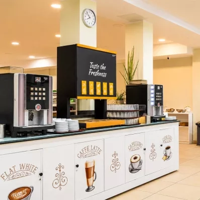 Une station de boissons en libre-service équipée de machines à café et de jus de fruits.