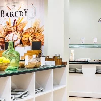 Un alignement de buffets organisés pour le service du petit-déjeuner dans un cadre contemporain.