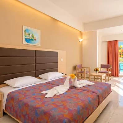 Chambre double avec deux lits collés  avec une porte fenêtre directement sur la piscine  