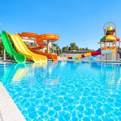 La piscine extérieur avec toboggans colorés et un ciel bleu