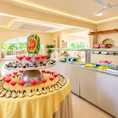 restaurant principal avec tables et chaises et avec buffet varié de crudités 