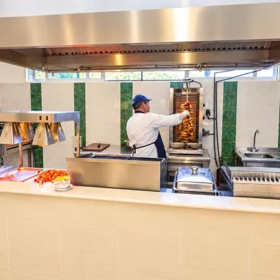 Chef cuisiner derrière le comptoir du restaurant préparant du Kebab  