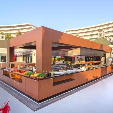 Un large buffet moderne et boisée située en extérieur au cœur du complexe hôtelier.