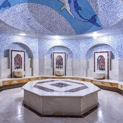 Un hammam traditionnel en marbre blanc doté d'une coupole ornée d'une mosaïque.