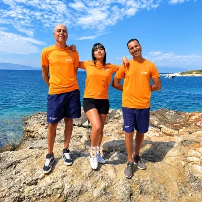 Trois animateurs qui posent sur un rocher vue sur la mer.