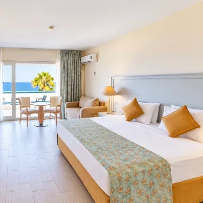Une vaste chambre disposant d'un grand lit, d'un canapé et d'une vue imprenable sur la mer.