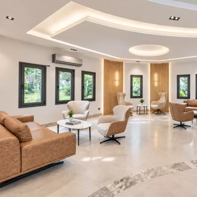 Un salon d'hôtel moderne et lumineux aux tons neutres, avec des fauteuils élégants.