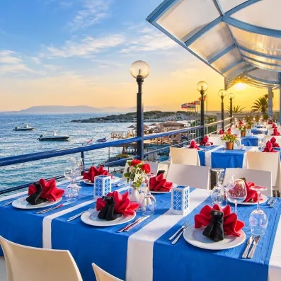 Des tables de restaurant dressée pour le dîner sur une jetée, au coucher du soleil.