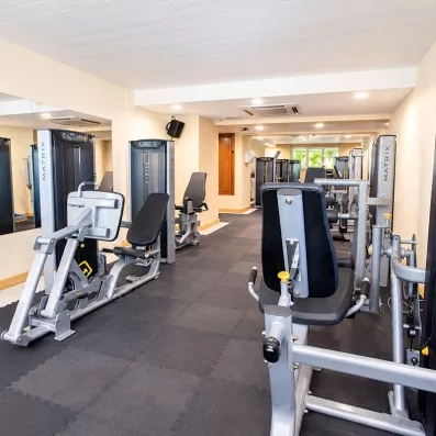 salle de fitness, machines de sport, tapis de course, vue sur l'extérieur, végétation luxuriante