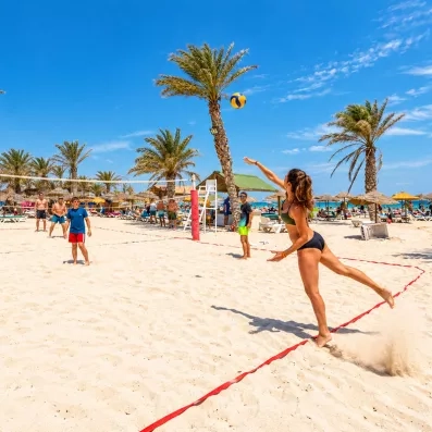 Partie de beach-volley sur la plage de l'hôtel Welcome Meridiana Djerba sous le soleil.