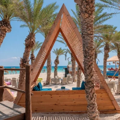 Structure triangulaire en bois sur la plage avec vue sur la mer turquoise à Djerba