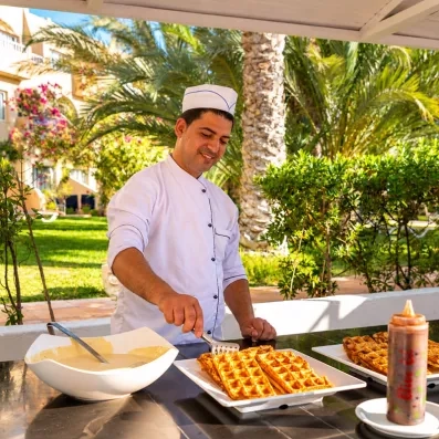 Chef préparant des gaufres fraîches au stand snack de l'hôtel tout inclus Welcome Meridiana Djerba
