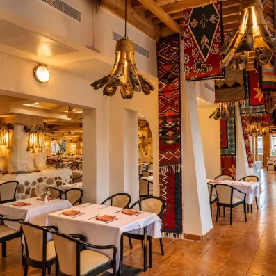 Salle de restaurant de style tunisien traditionnel avec tapis et luminaires au Welcome Meridiana Djerba