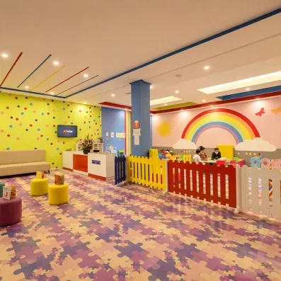mini club pour enfants avec un arc en ciel peint sur le mur et un parc de jeux jeux