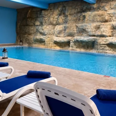 piscine intérieure chauffée avec des transats au bord de la piscine
