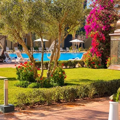 piscine entourée d'arbres et de fleurs rouge