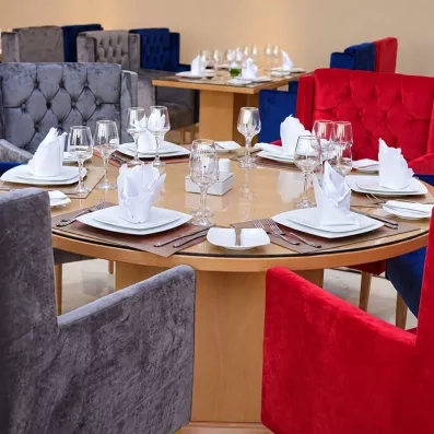 restaurant avec table  ronde et chaise capitonnées en rouge et gris