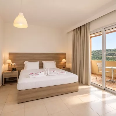 Chambre avec un grand lit double et balcon.