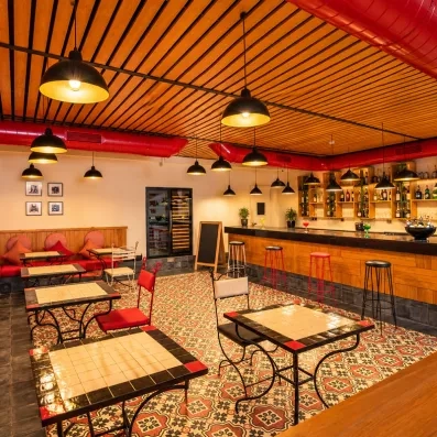 tables et chaises du restaurant à la carte de l'hôtel avec des coussins rouges
