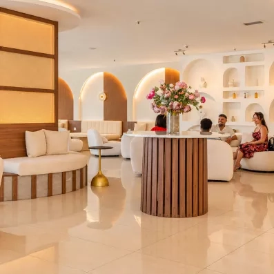 réception de l'hôtel avec des fauteuils blancs et une table ronde au milieu avec un bouquet de fleur