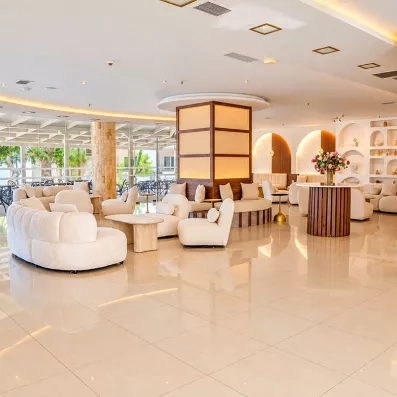 réception de l'hôtel avec des fauteuils blancs et un comptoir d'accueil 
