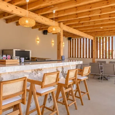 bar, chaises en bois, lampes rondes, poutres en bois apparentes, bières