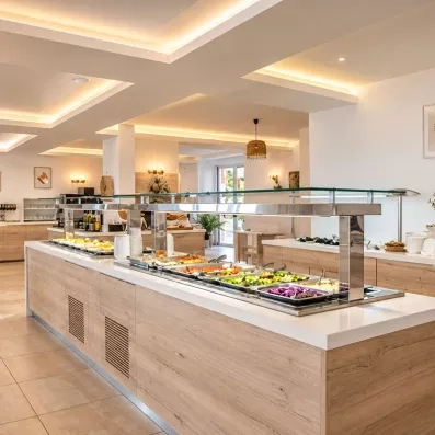 Buffet de l'hôtel varié, grande salle blanche épurée, crudités, salades, tomates