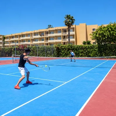 personnes jouant au tennis dans la cour extérieur de l'hôtel