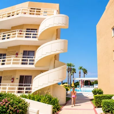 façade hôtel avec escaliers en colimaçon passage vers la piscine