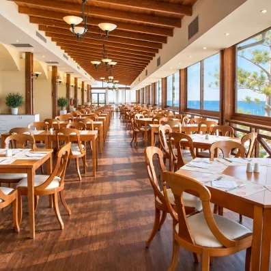 grande salle de restaurant avec des tables et des chaises et des fenêtres en vitre