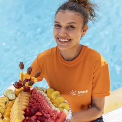 Animatrice Mondi Club présentant un plateau de fruits au club tout inclus Aladin Djerba
