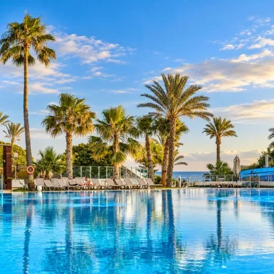 Grande piscine extérieure bordée de palmiers et transats au Mondi Club Nozha Beach Hammamet